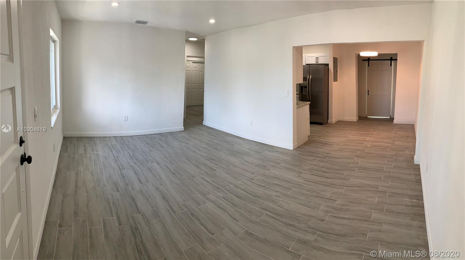 3670 Northwest 16th Street Miami, FL 33125 - Photo 4 of 17 an empty room with wooden floor and windows
