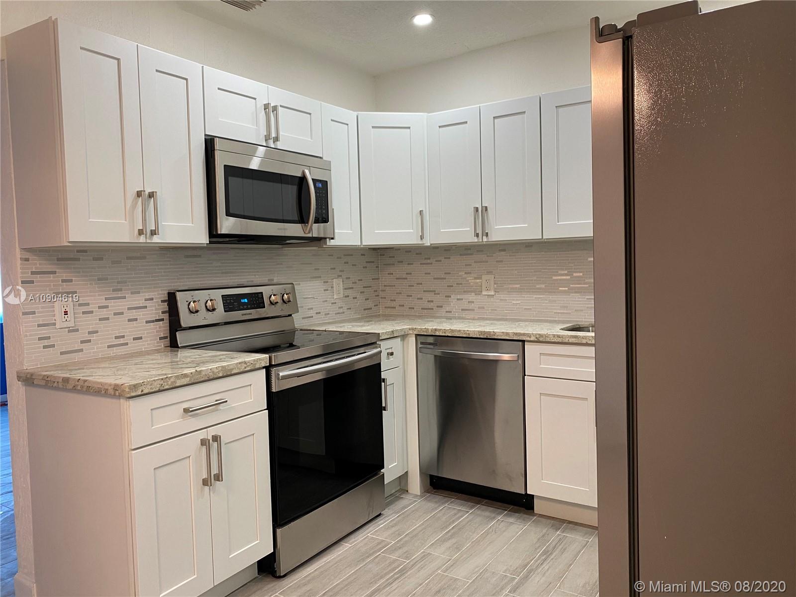 3670 Northwest 16th Street Miami, FL 33125 - Photo 5 of 17 a kitchen with stainless steel appliances granite countertop a stove and a microwave
