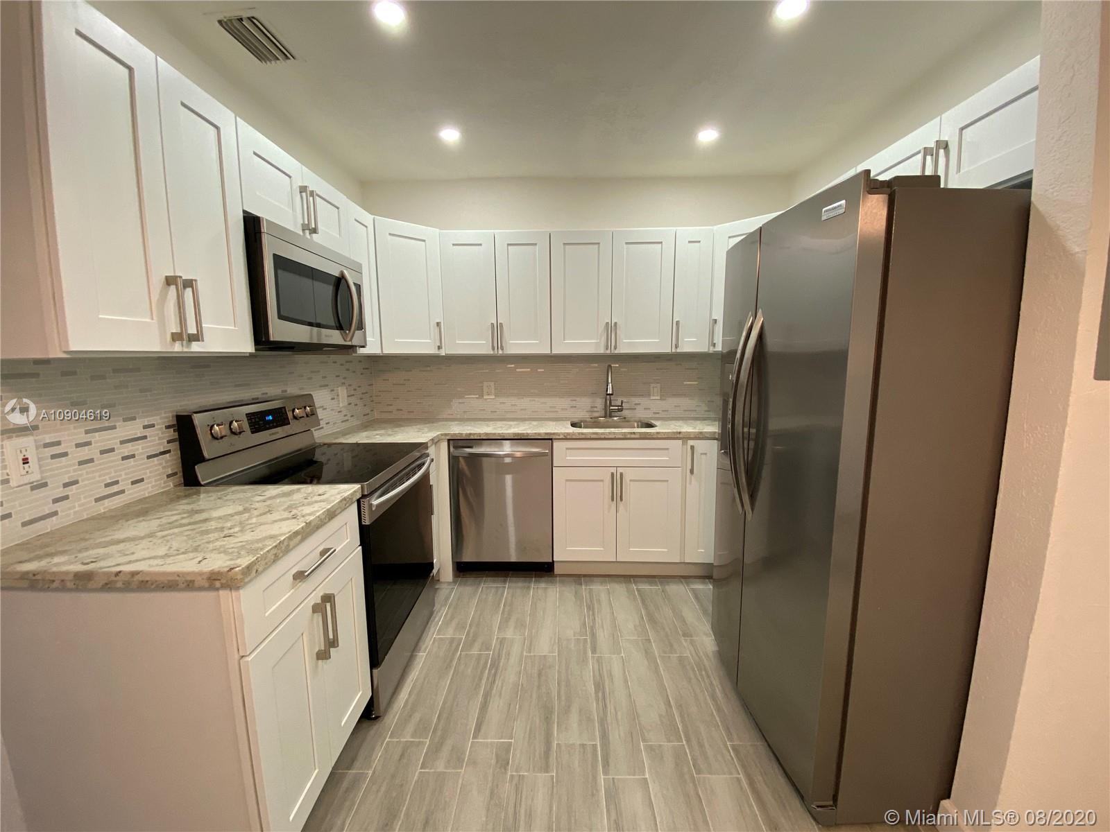 3670 Northwest 16th Street Miami, FL 33125 - Photo 6 of 17 a kitchen with stainless steel appliances a refrigerator stove microwave and sink