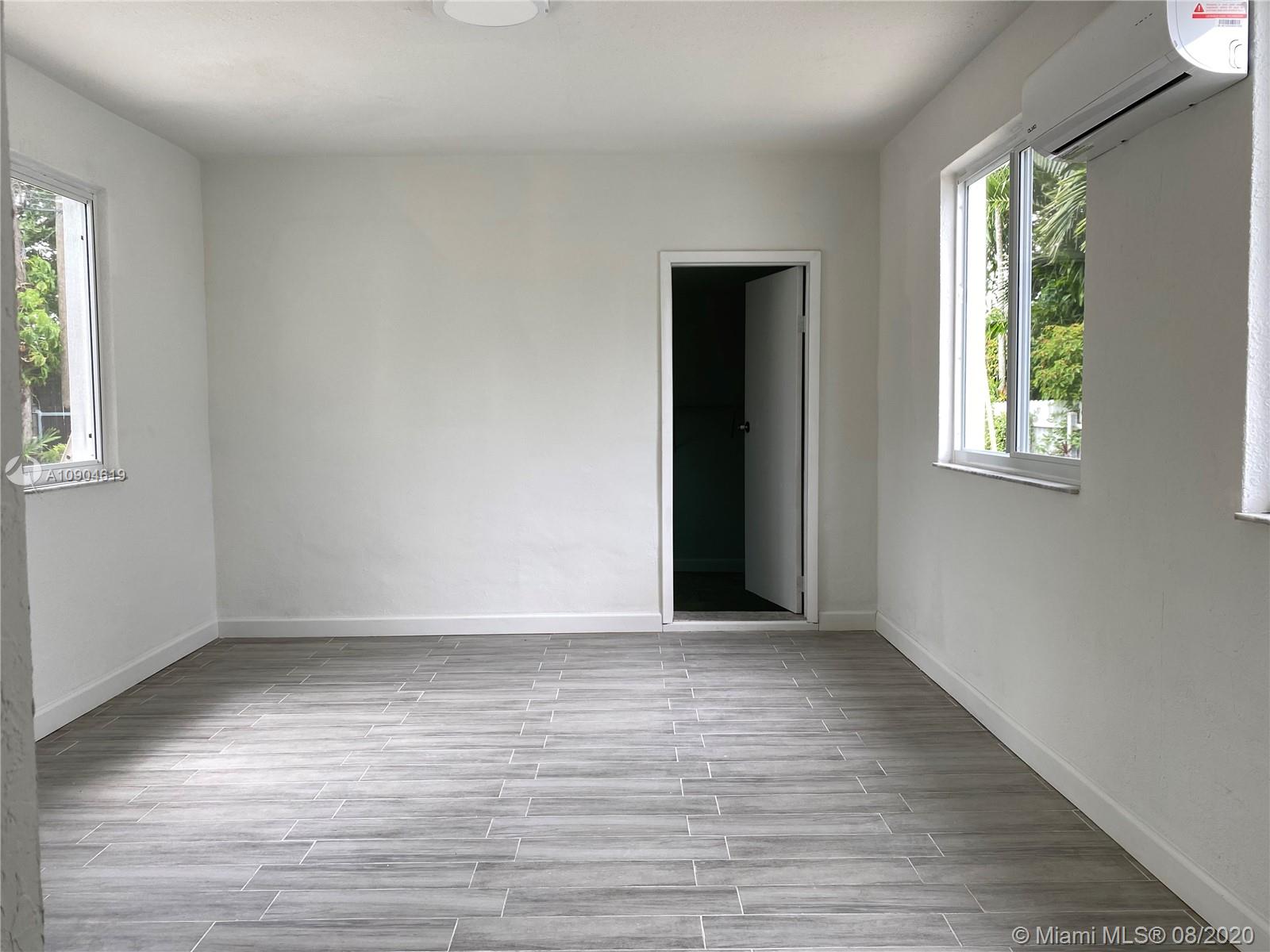 3670 Northwest 16th Street Miami, FL 33125 - Photo 7 of 17 a view of an empty room with wooden floor and a window