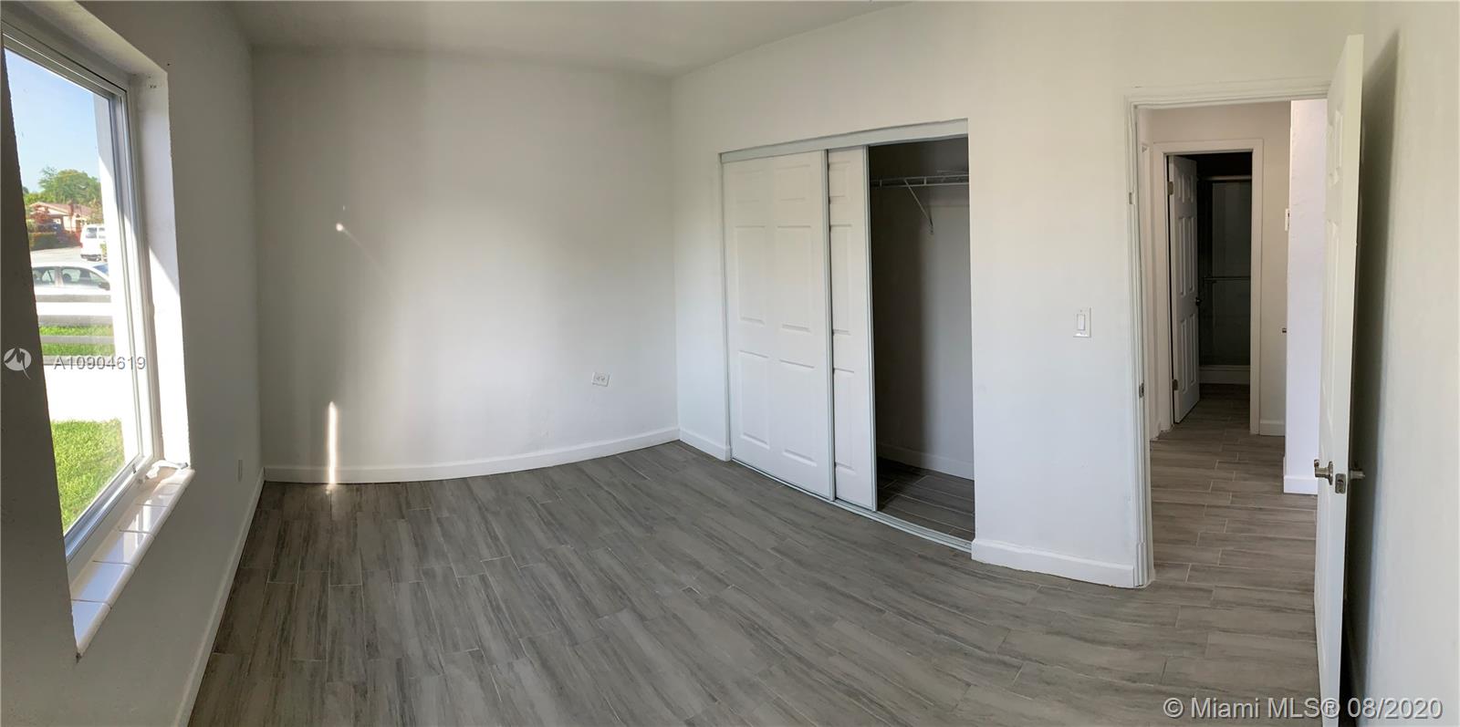 3670 Northwest 16th Street Miami, FL 33125 - Photo 9 of 17 an empty room with wooden floor and windows
