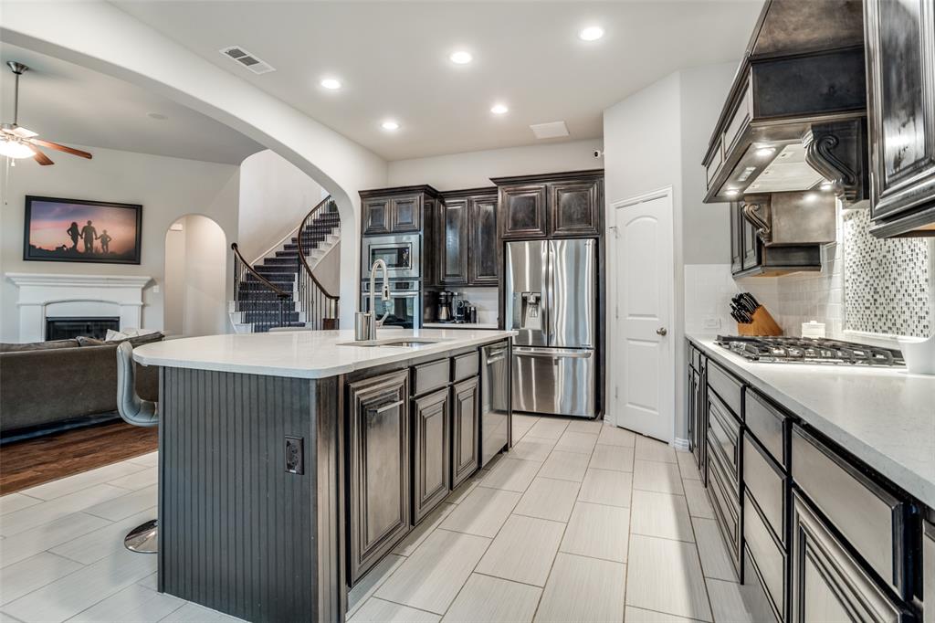 3410 Challis Trail McKinney, TX 75070 - Photo 13 of 31 a kitchen with stainless steel appliances a sink and a refrigerator