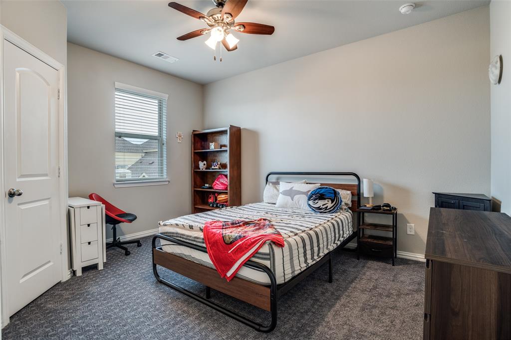 3410 Challis Trail McKinney, TX 75070 - Photo 22 of 31 a bedroom with a bed and a chandelier