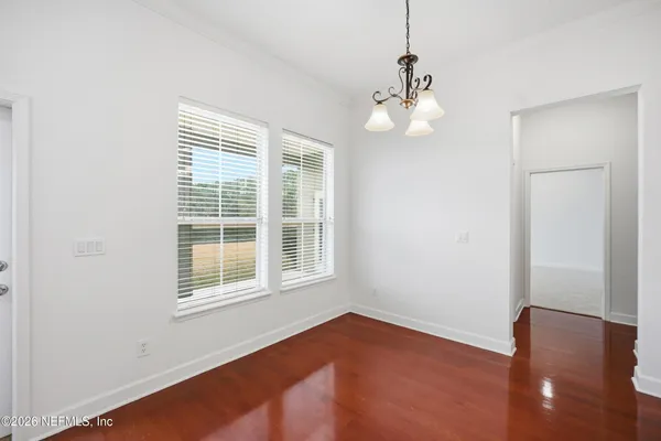 an empty room with wooden cabinet and windows
