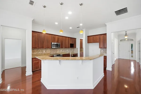a large kitchen with stainless steel appliances granite countertop a stove and a refrigerator
