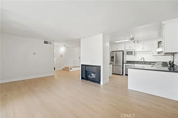a kitchen with granite countertop a refrigerator sink and cabinets
