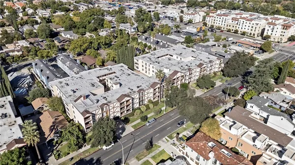 an aerial view of a multi story residential apartment building with parking space