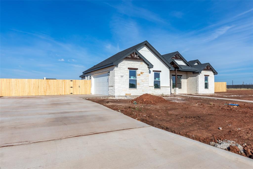 120 Indian Ridge Tuscola, TX 79562 - Photo 6 of 8 Stone and siding exterior with dark-framed windows, a dark shingled roof, an attached garage, and a concrete driveway