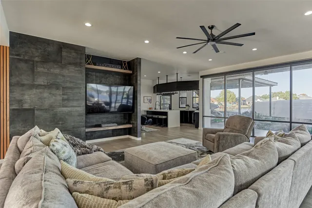 a living room with furniture ceiling fan and a floor to ceiling window