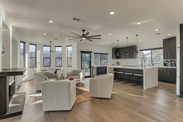 a large living room with stainless steel appliances kitchen island granite countertop a large window and a kitchen view