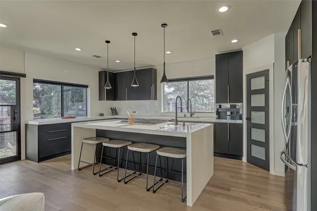 a kitchen with kitchen island granite countertop a sink and refrigerator
