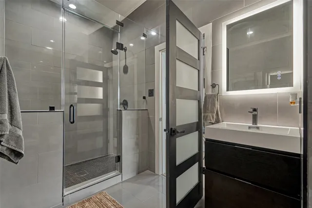 a bathroom with a granite countertop sink mirror and shower