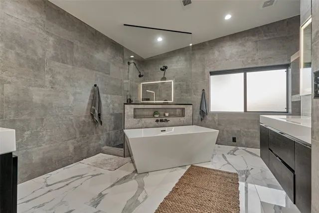 a spacious bathroom with a double vanity sink a mirror and a bathtub