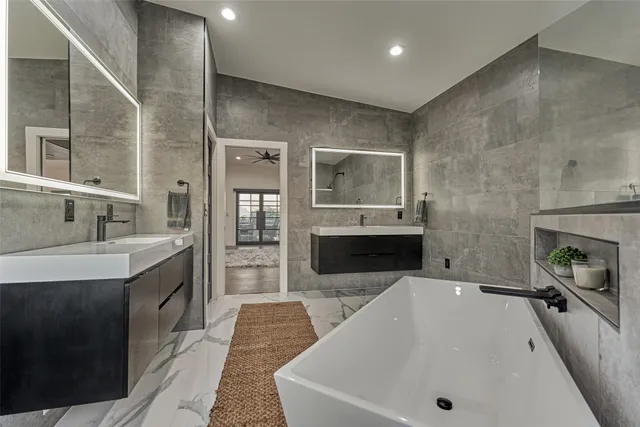 a bathroom with a tub sink and mirror