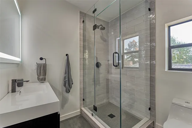 a bathroom with a shower sink and mirror