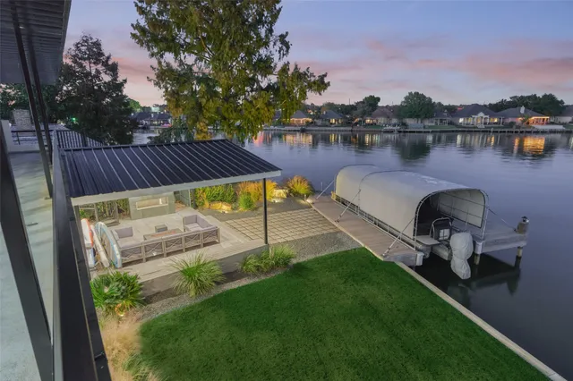 a view of a backyard with sitting area and lake view