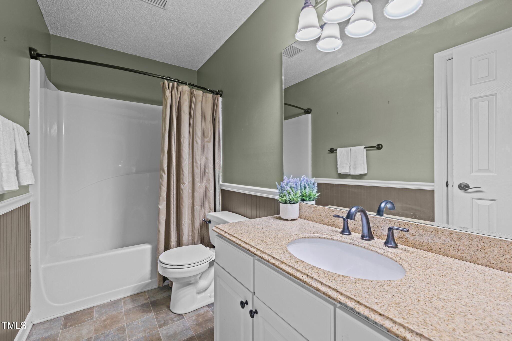 209 Priceview Drive Raleigh, NC 27603 - Photo 13 of 20 a bathroom with a granite countertop sink toilet mirror and a bathtub