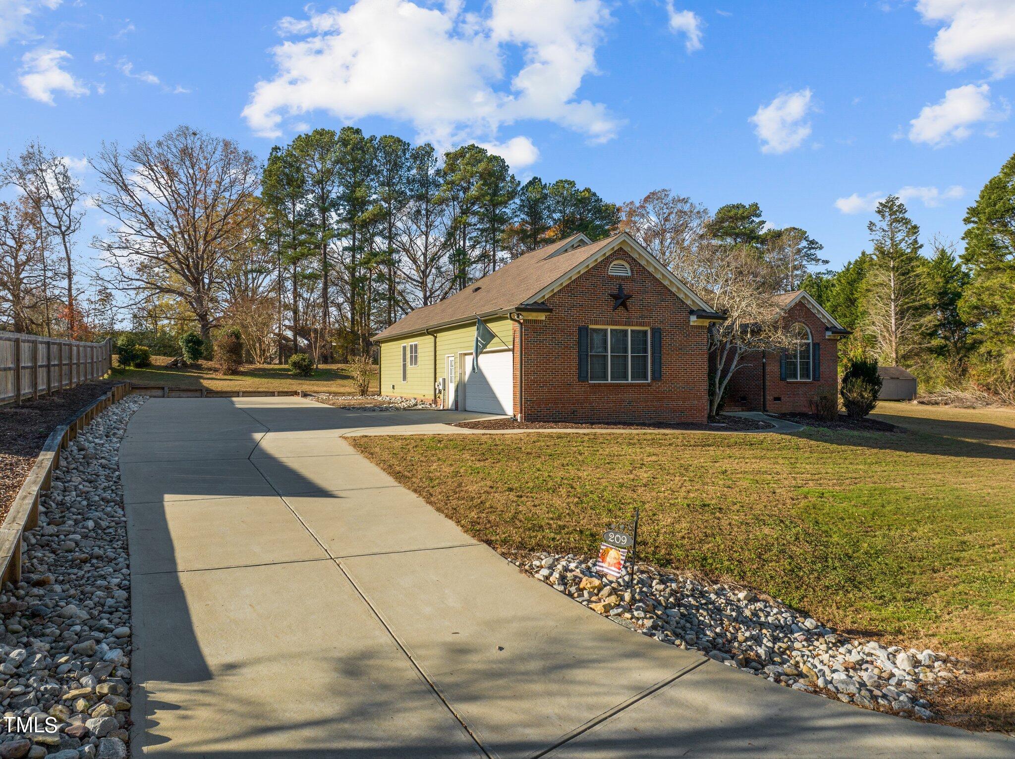 209 Priceview Drive Raleigh, NC 27603 - Photo 19 of 20 a front view of a house with a garden