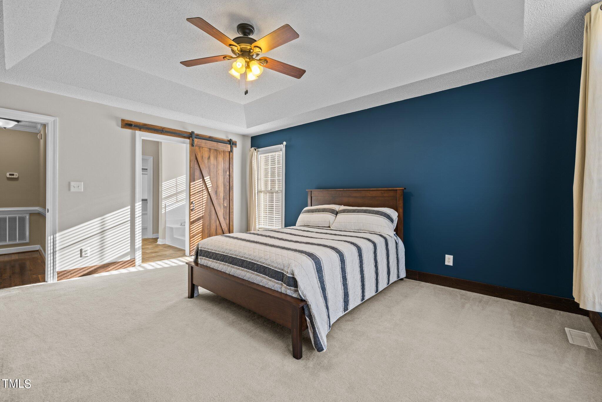 209 Priceview Drive Raleigh, NC 27603 - Photo 8 of 20 a bedroom with a bed and a chandelier