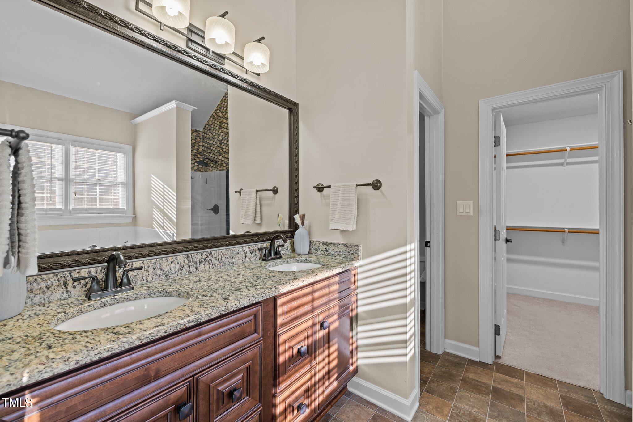 209 Priceview Drive Raleigh, NC 27603 - Photo 9 of 20 a en suite bathroom with a granite countertop sink and a mirror