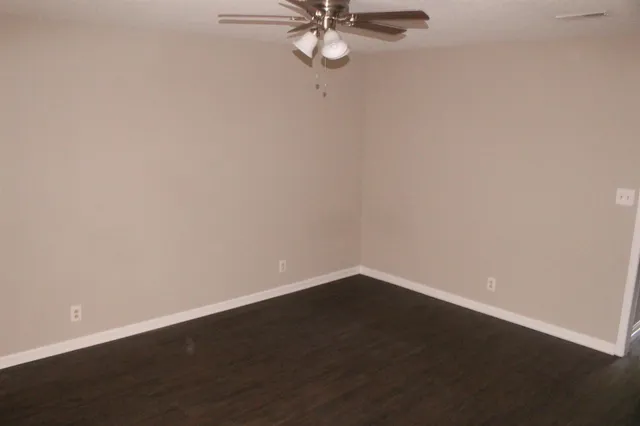 a view of a small space with wooden floor and a ceiling fan