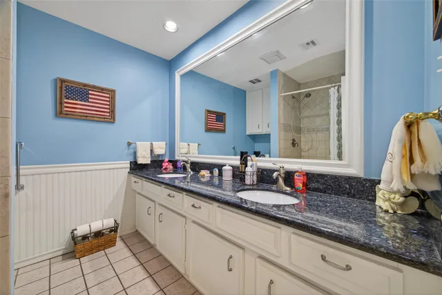 a bathroom with a granite countertop sink a mirror a shower and a bathtub