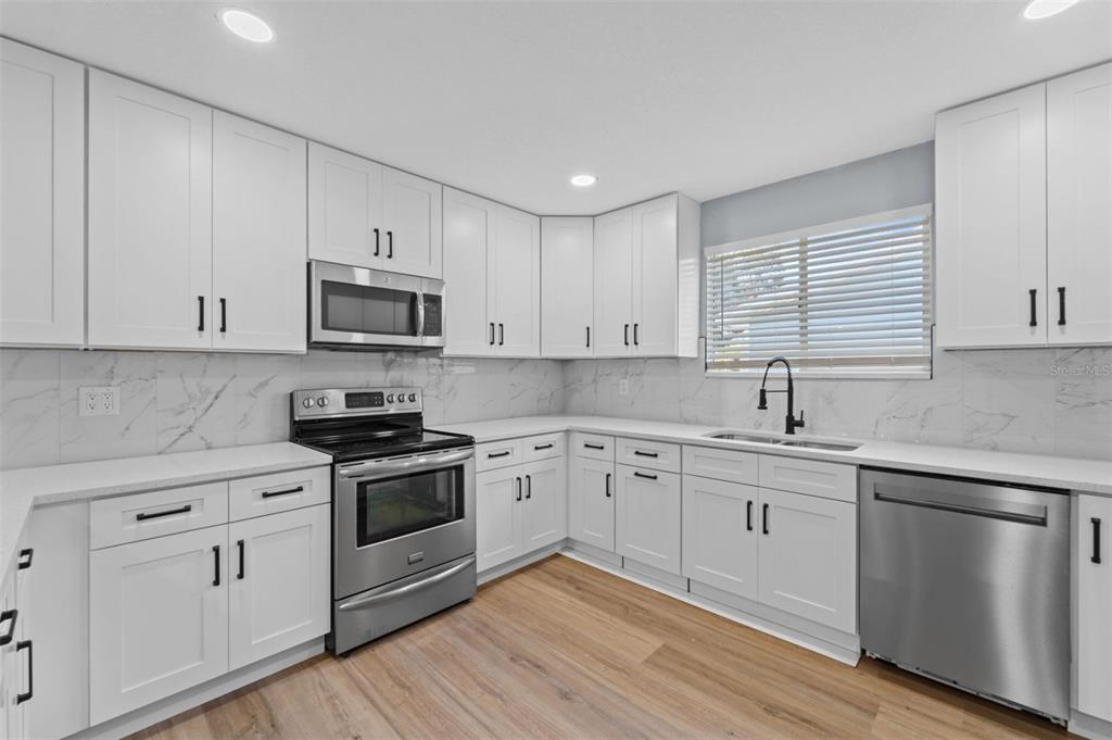 8170 Southwest 109 Street Road Ocala, FL 34481 - Photo 8 of 18 a kitchen with cabinets stainless steel appliances a sink and a window