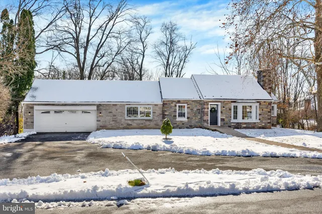 a front view of a house with a yard covered with snow
