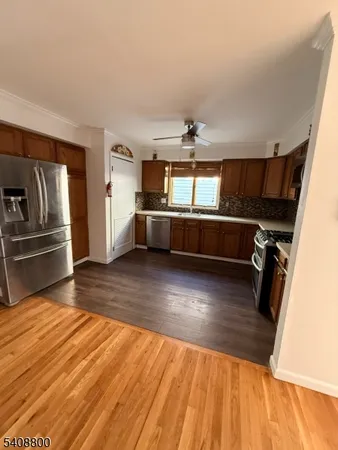 a view of a kitchen with a sink and wooden floor