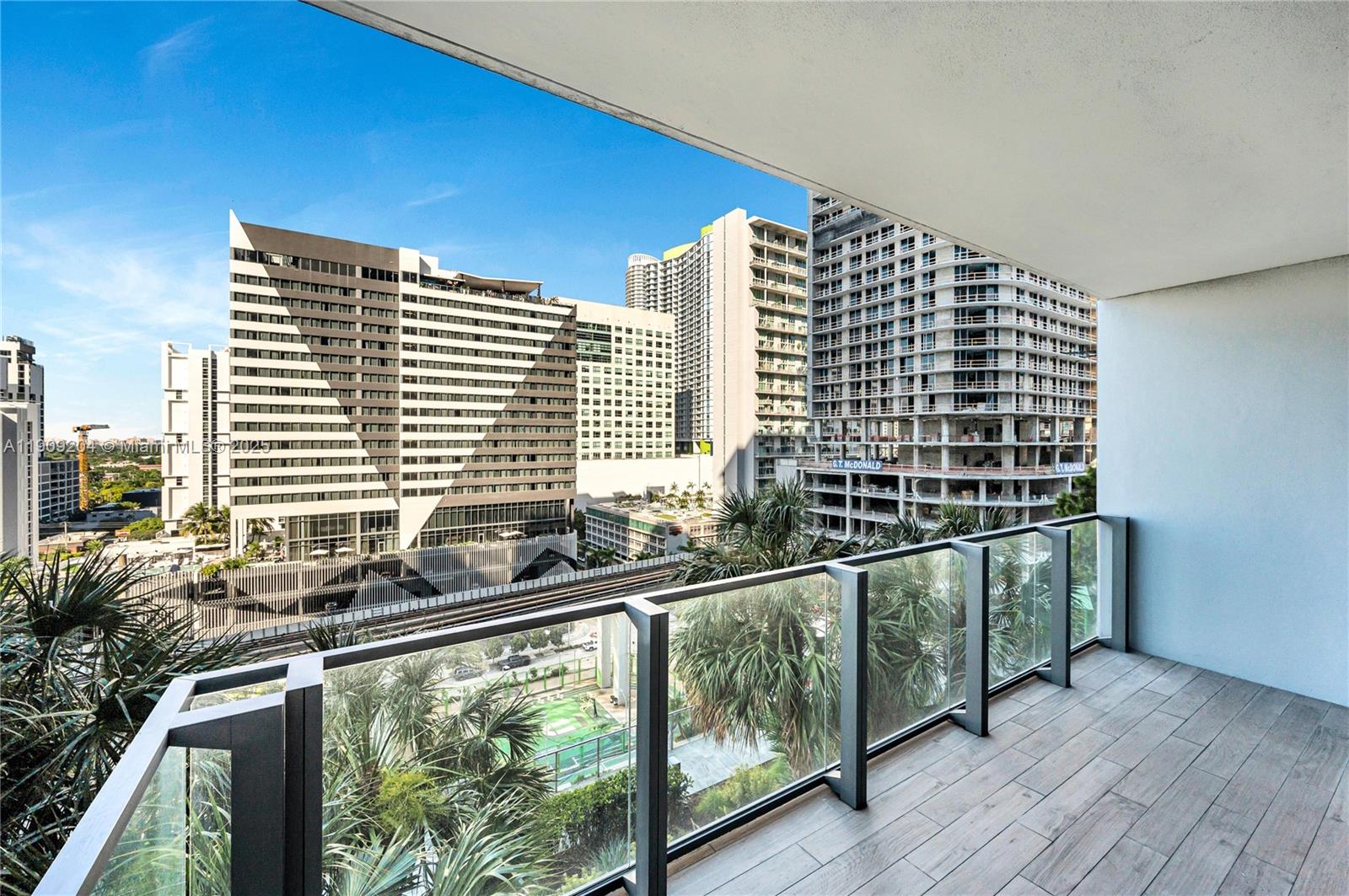 88 Southwest 7th Street, Unit 806 Miami, FL 33130 - Photo 18 of 54 a view of a balcony with floor to ceiling windows and wooden floor