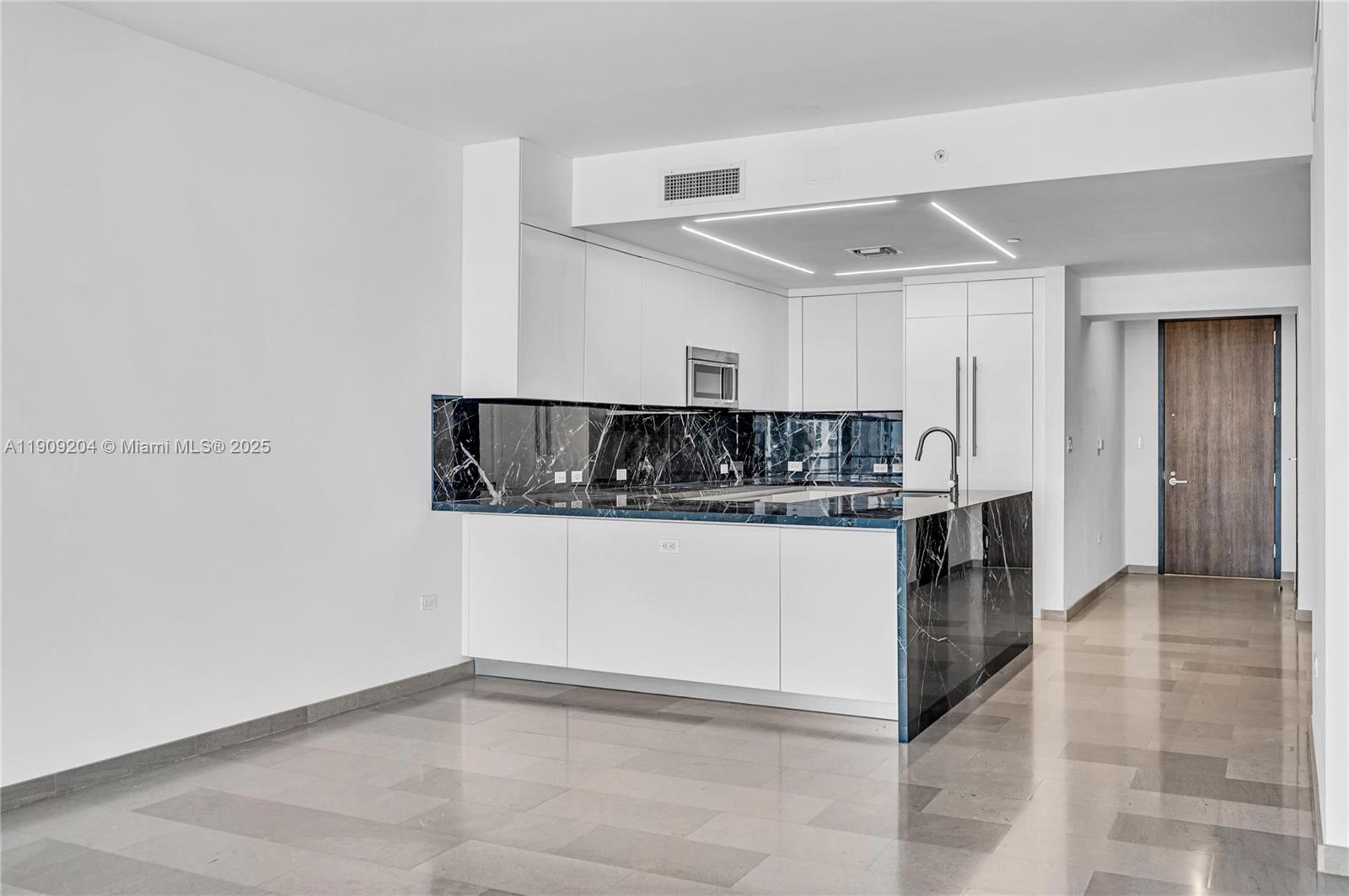88 Southwest 7th Street, Unit 806 Miami, FL 33130 - Photo 24 of 54 a kitchen with kitchen island a counter top space and cabinets