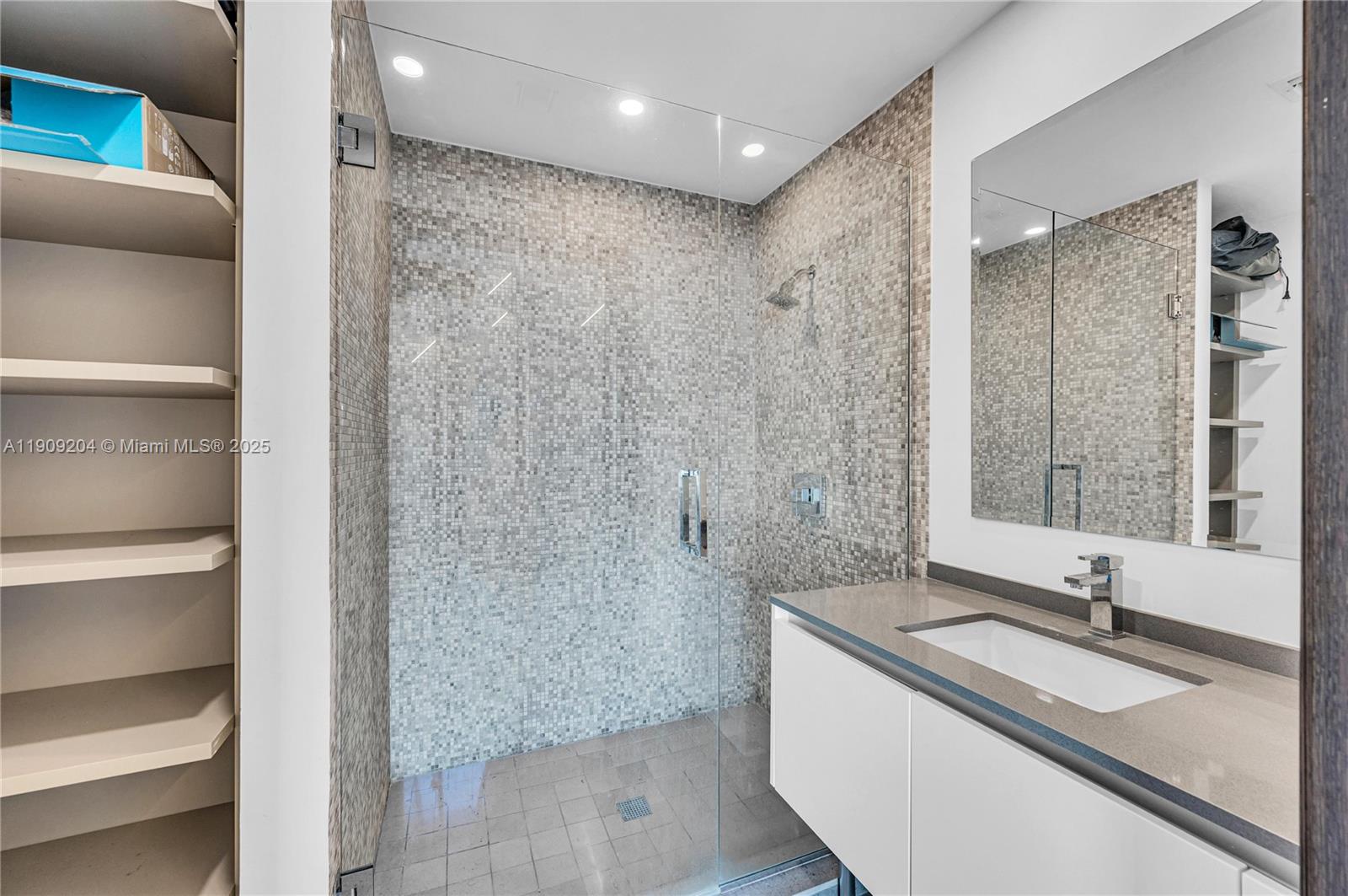 88 Southwest 7th Street, Unit 806 Miami, FL 33130 - Photo 28 of 54 a bathroom with a granite countertop sink a mirror and a shower