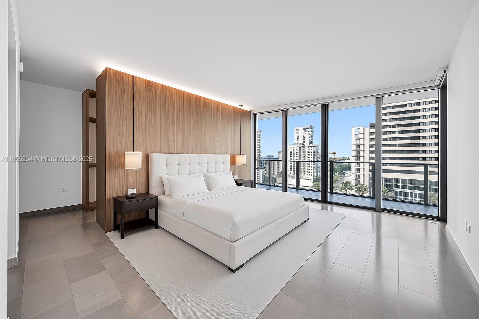 88 Southwest 7th Street, Unit 806 Miami, FL 33130 - Photo 32 of 54 a spacious bedroom with a large bed and a chandelier