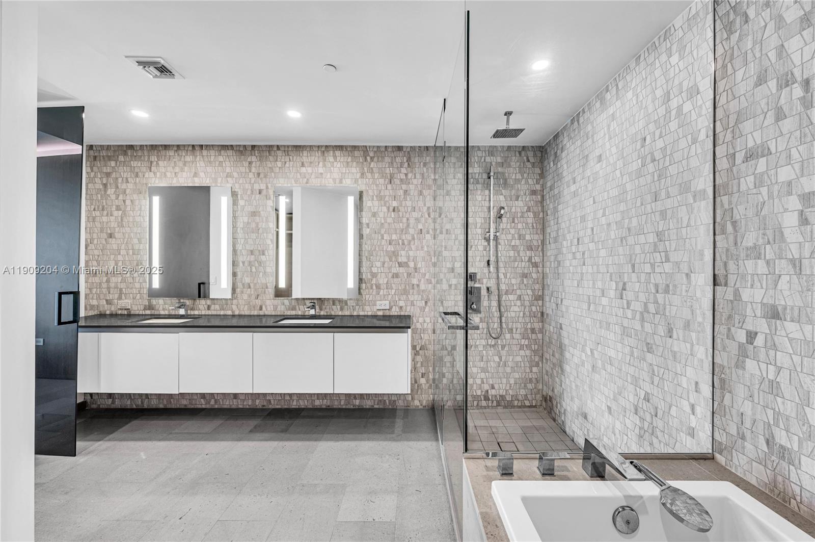 88 Southwest 7th Street, Unit 806 Miami, FL 33130 - Photo 42 of 54 a bathroom with a granite countertop sink mirror and a bathtub