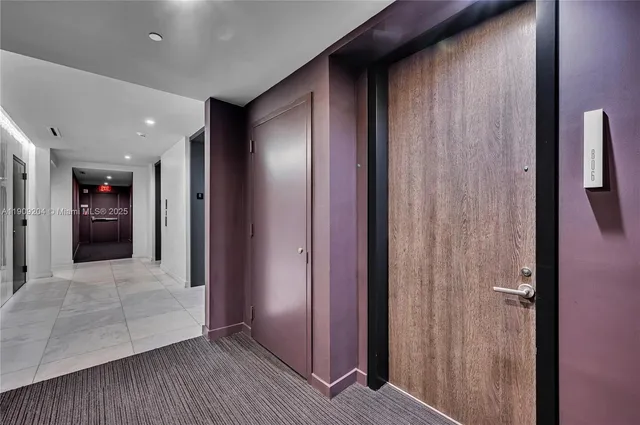 a view of hallway with stainless steel appliances granite countertop cabinets and window