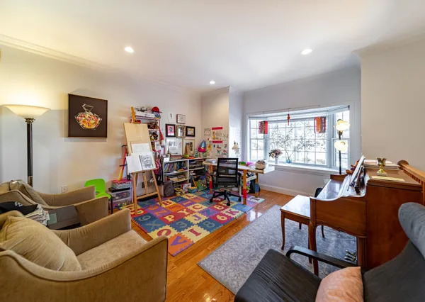 a living room with furniture a flat screen tv and a window