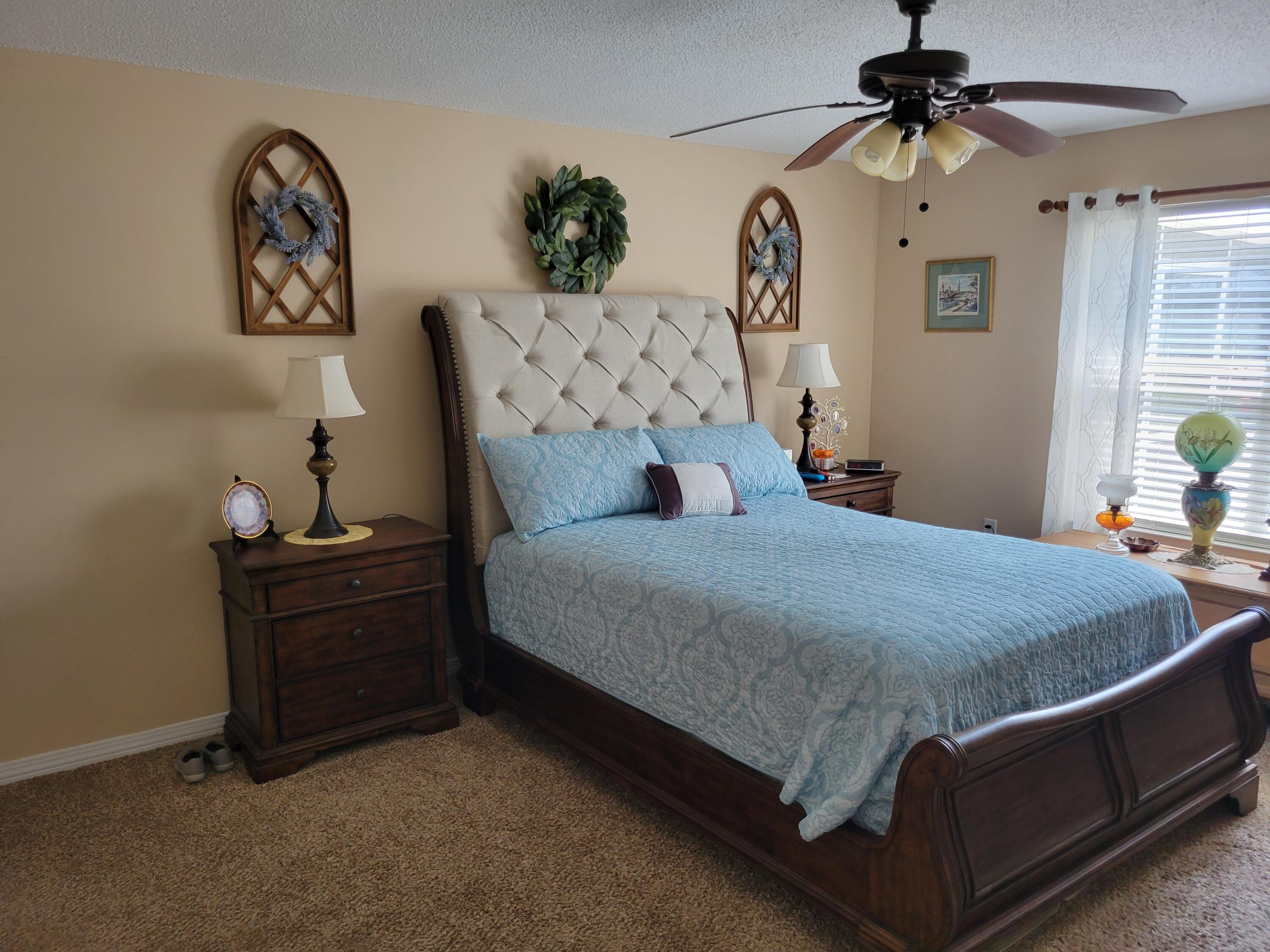 4712 Whitewater Lane Crestview, FL 32539 - Photo 19 of 25 a bed sitting in a bedroom and a chandelier