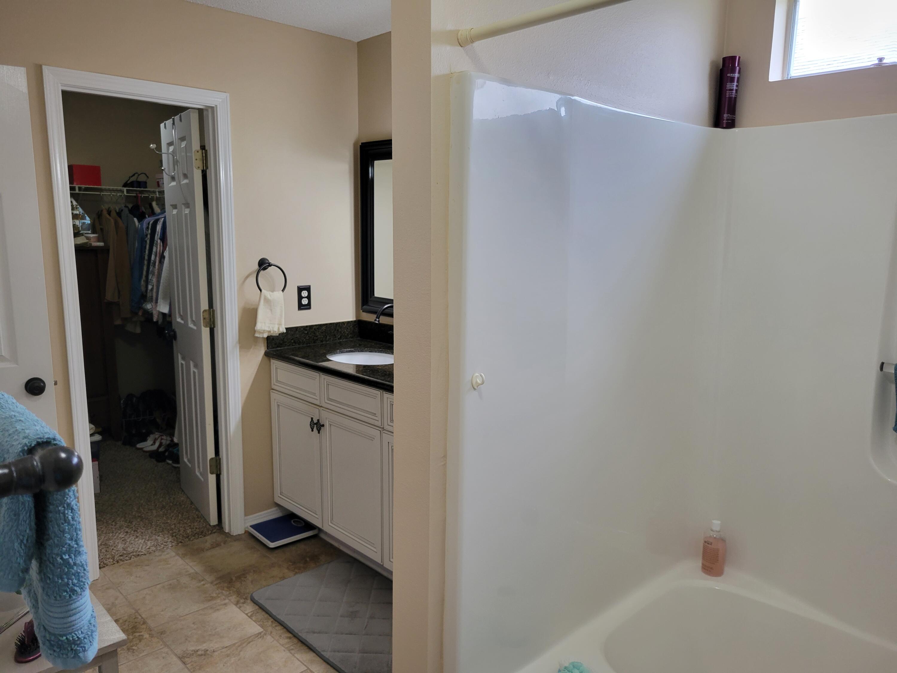 4712 Whitewater Lane Crestview, FL 32539 - Photo 21 of 25 a bathroom with a granite countertop sink and a bathtub