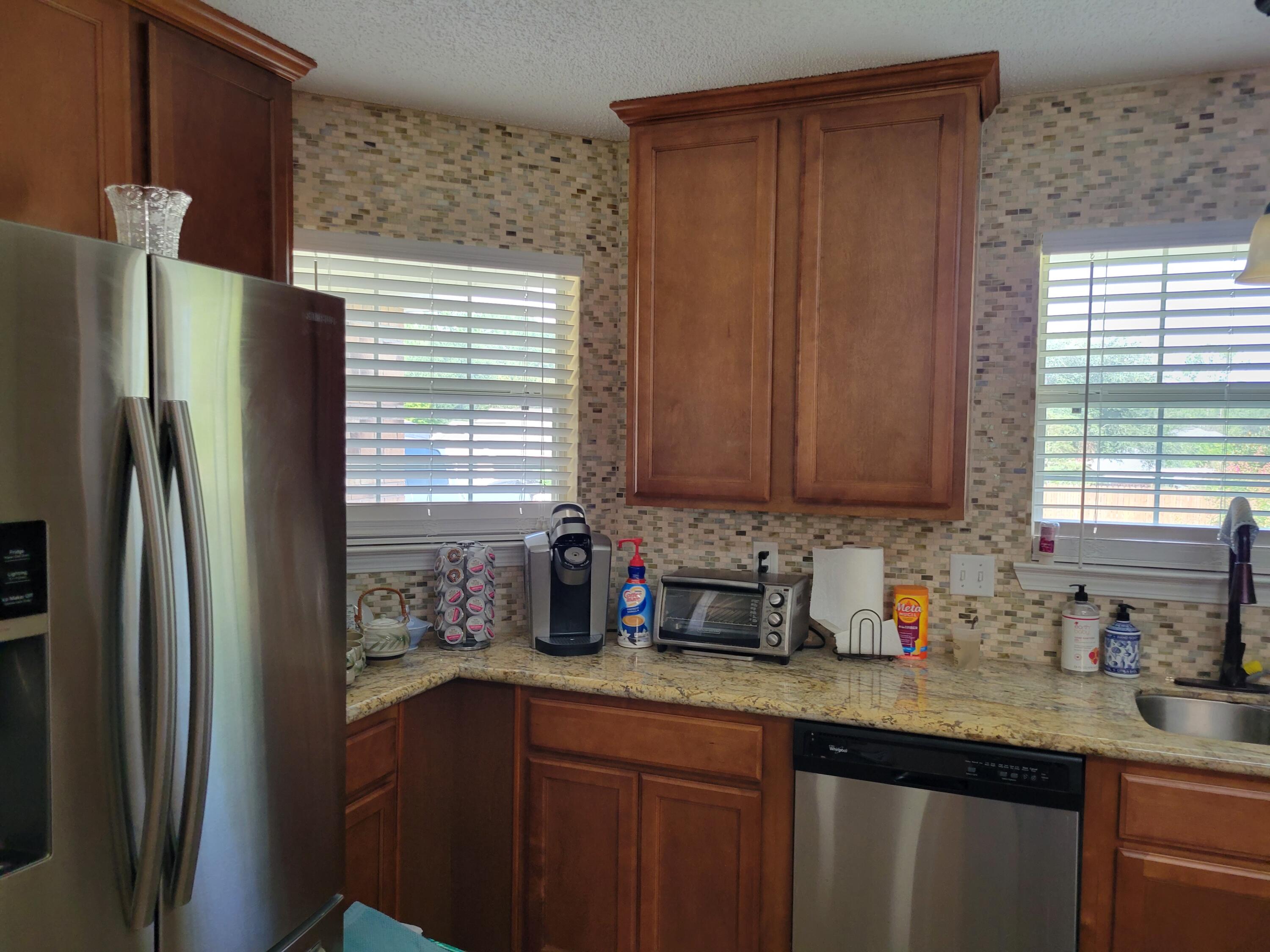 4712 Whitewater Lane Crestview, FL 32539 - Photo 24 of 25 a kitchen with stainless steel appliances granite countertop a refrigerator and a sink