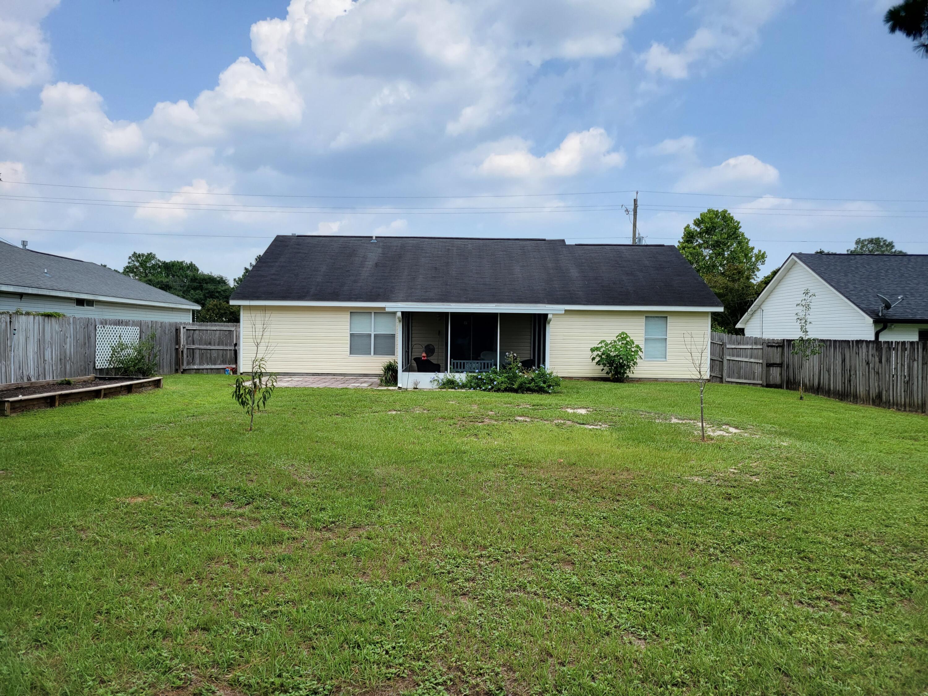 4712 Whitewater Lane Crestview, FL 32539 - Photo 3 of 25 a front view of a house with a garden and deck