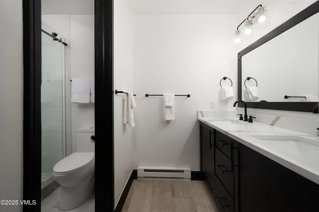 a bathroom with a sink a toilet and shower