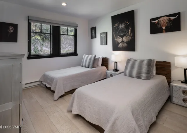 a bedroom with two beds and a flat screen tv