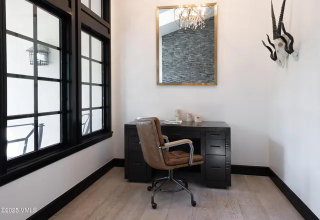 a view of a workspace with furniture and a window
