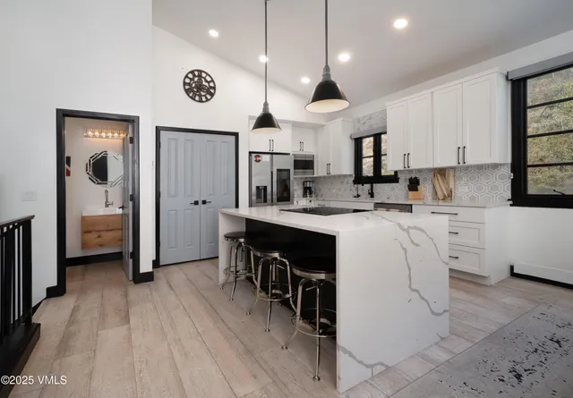 a kitchen with stainless steel appliances kitchen island granite countertop a sink and cabinets