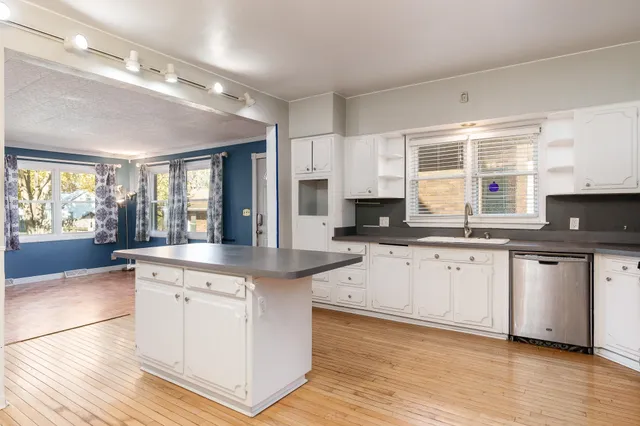 a large kitchen with cabinets and wooden floor