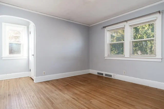 a view of a room with wooden floor and windows