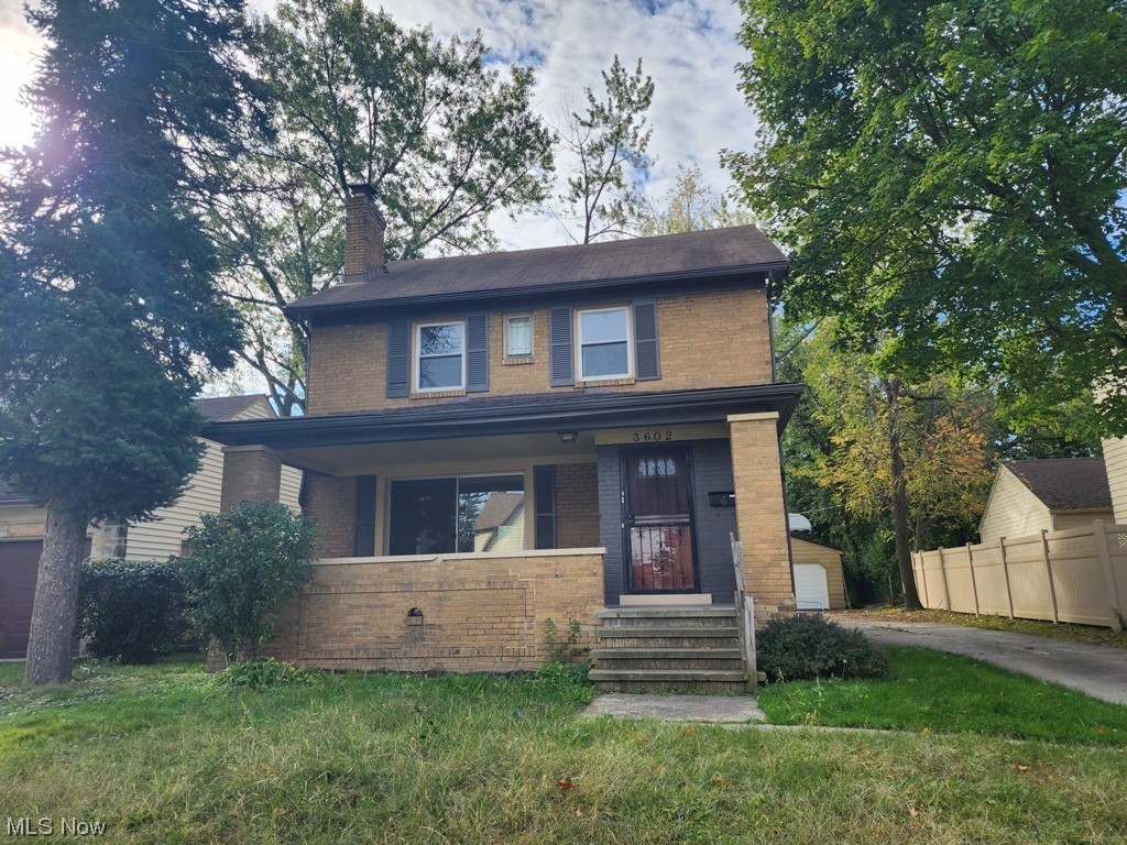 View of front of house featuring a front lawn and covered porch