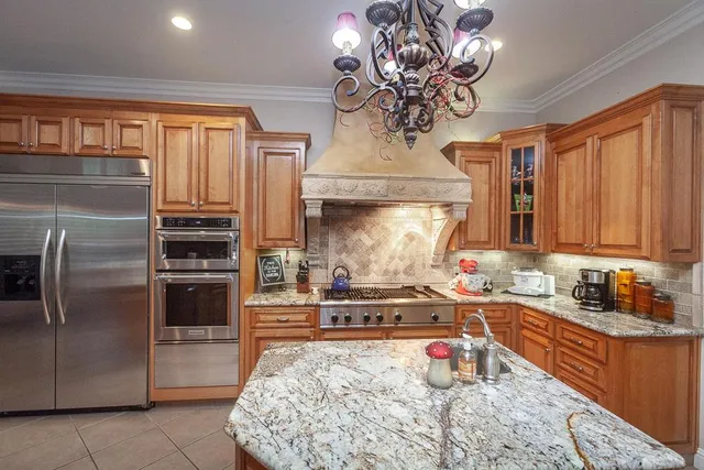 a spacious bedroom with a bed a couch and a chandelier