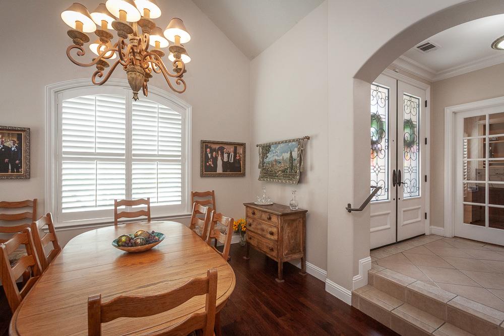 1111 Brighton Way Lodi, CA 95242 - Photo 27 of 87 a dining room with wooden floor a chandelier a glass table and chairs