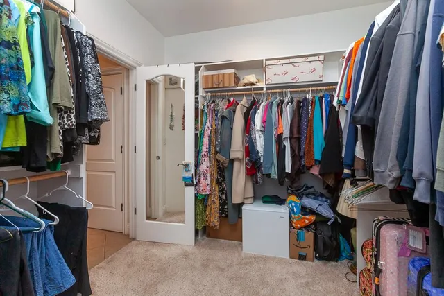 a view of walk in closet with clothes and shoes